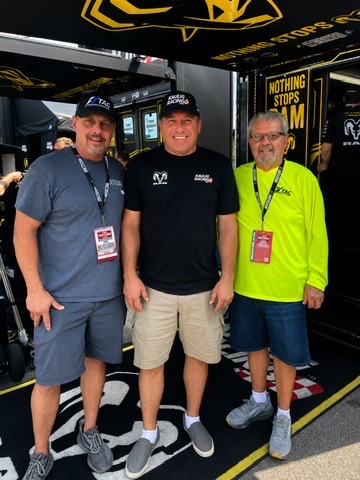 Danny Leone, Ryan Newman, and Bill Leone standing together in front of the Kaulig Racing RAM hauler